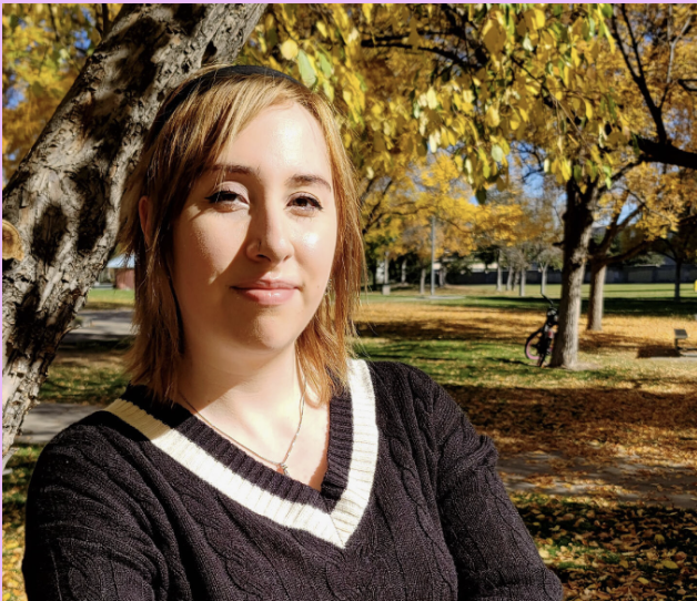 Kelsey Foster headshot. A white woman standing outside smiling for the photo.